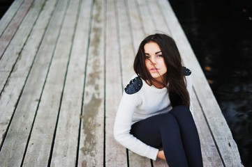 Fototapeta premium beautiful young brunette woman in white blouse and black leggings posing
