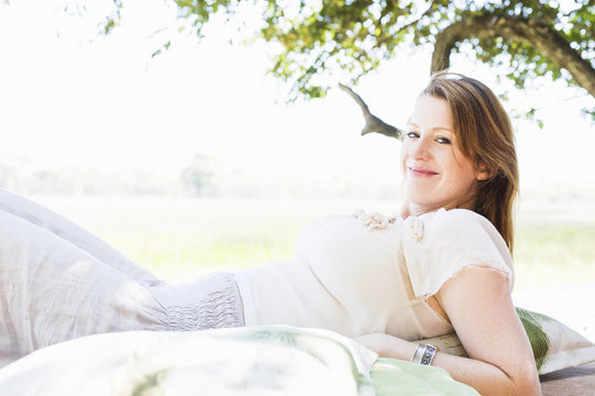 Portrait of young woman reclining on daybed at safari lodge, Kafue National Park, Zambia