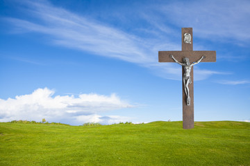 Jesus Christ on the cross and summer grass with blue sky