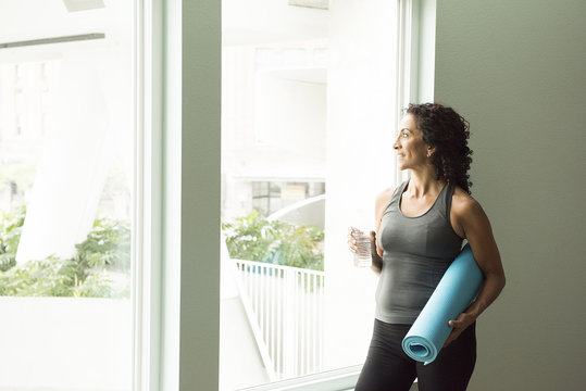 Mature woman drinking water after yoga