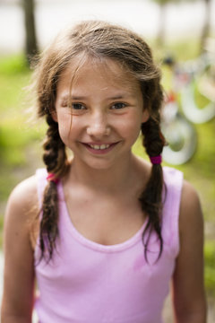 High angle portrait of young girl with pigtails looking at camera smiling