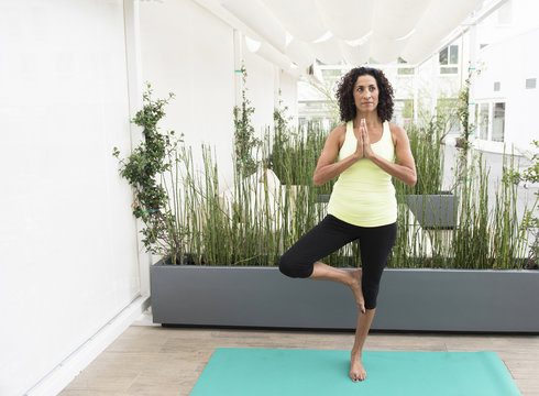 Mature woman doing yoga tree pose