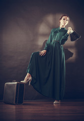 Woman retro style with old suitcase and fan