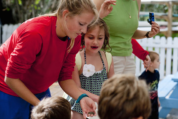 Young woman holding sea creature, showing children