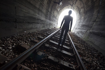 Man in a tunnel looking towards the light