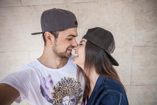 Young couple wearing cap, in loving embrace