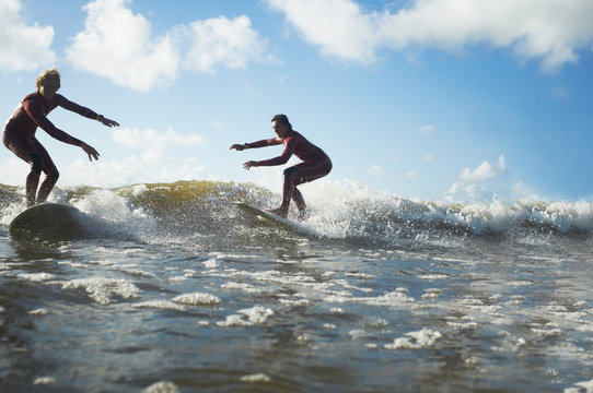 Two surfers riding wave