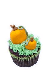 close-up image of cupcake with pumpkin miniature
