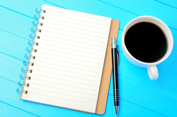 Notebook with cup of coffee and pen