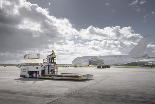 Freight handling machine with A380 aircraft on runway