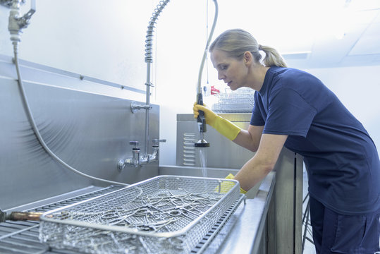 Worker Cleaning Surgical Instruments In Ultrasonic Bath In Surgical Instrument Factory