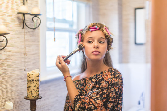Teenager putting on make-up in bathroom