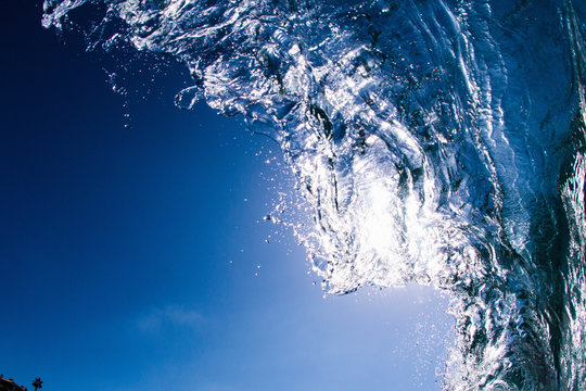 Low angle view of blue ocean wave rolling and splashing overhead