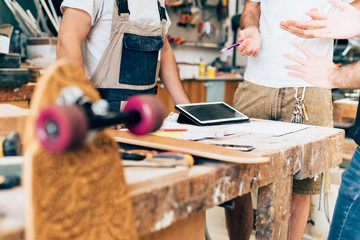 Young men working in skateboard workshop