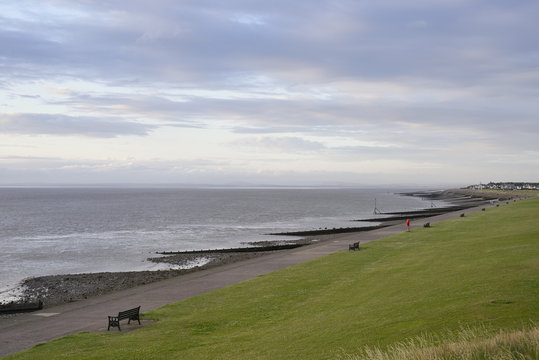 Rows of park benches on Solway Firth waterfront, Silloth, Cumbria, UK