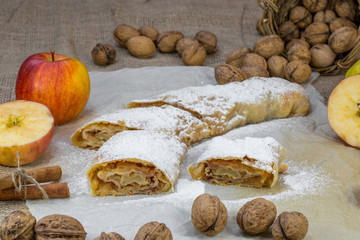 Sugared Homemade Apple Strudel on a Baking Paper with Walnuts, C