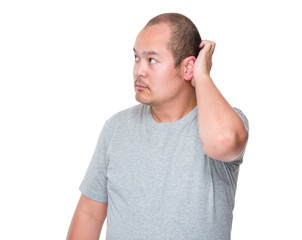 Confused mid adult man scratching his head