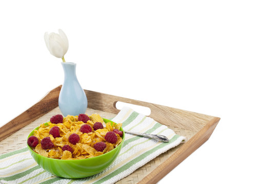 close up image bowl of cereal and raspberries on tray