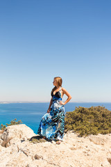 young beautiful caucasian female on a cliff above the sea