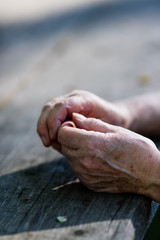wrinkled hands of an old woman on a table