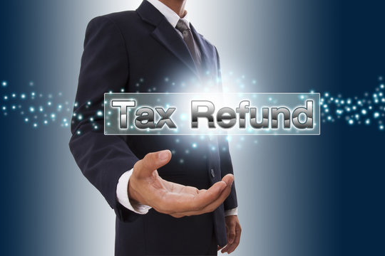 Businessman hand showing tax refund button on virtual screen. 