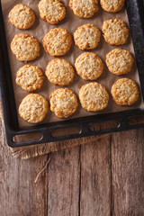 Australian oatmeal cookies close-up on a baking sheet. vertical top view
