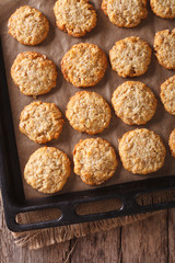 Tasty oatmeal cookies close-up on a baking sheet on the table. vertical top view
