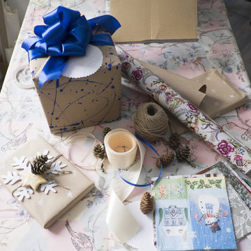 High angle view of gift wrapping and gift with blue bow on table
