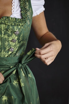 Young woman tying Dirndl apron