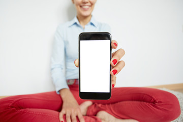 Cropped shot of smiling girl showing something interesting on cell phone isolated against white wall background. Close up of female hands holding smart phone with copy space for your advertisement