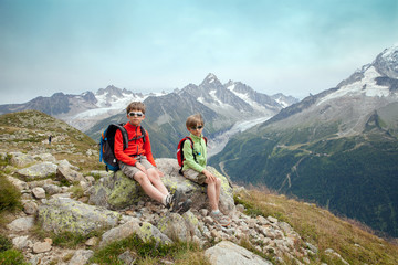 Fototapeta premium Two boys are sitting on slope of high mountain in the european Alps