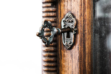 Vintage keyhole with key on vintage wooden cabinet with white background