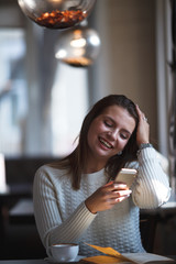 woman using her mobile phone at cafe