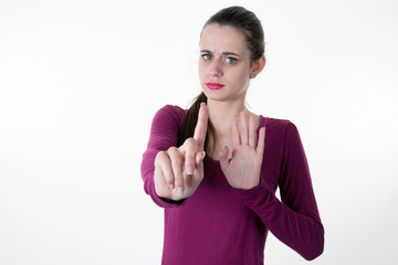 Young woman shows finger and palm of the hand meaning : stop