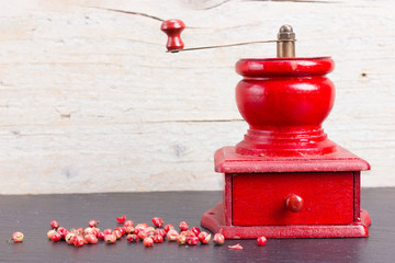 Vintage, red pepper mill with peppercorns