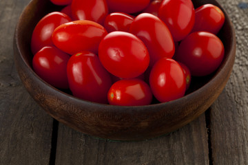 bunch of tomatoes in wooden bowl