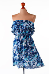Casual blue strapless dress. Floral dress on armless mannequin. Girl's clothing of light material. New collection of summer clothes.