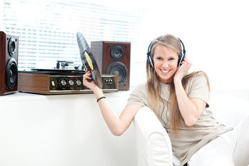 Young beautiful woman listen music with record in a living room