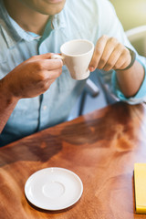 Cheerful young guy is spending time in cafe