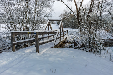 wooden bridge under snow