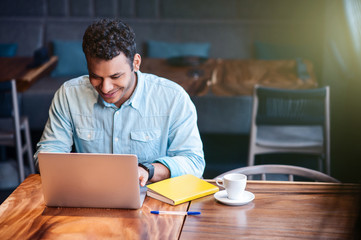 Handsome young guy is typing on computer