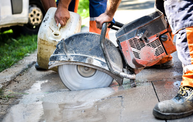 Construction worker cutting Asphalt paving for sidewalk