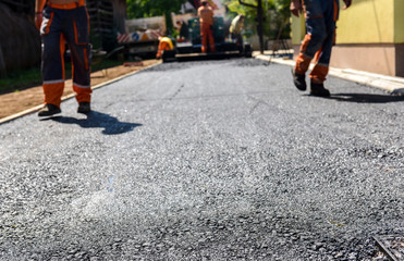 Team of Workers making and constructing asphalt road constructio