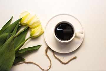 
Beautiful pale yellow flowers are on the table with a cup of coffee