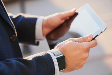 Male hands with smart watch keep tablet