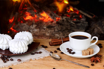 Coffee with spices and marshmallows on a background of a burning