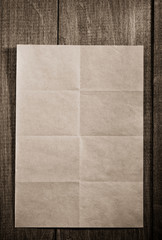folded note paper on wood