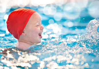 happy child with swimming pool cap have fun in a pool