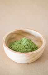 Premium green tea powder in wooden bowl
