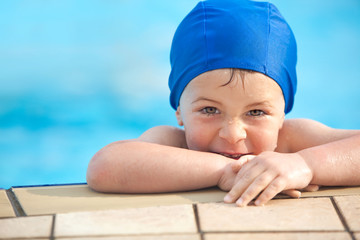 happy child with swimming pool cap have fun in a pool